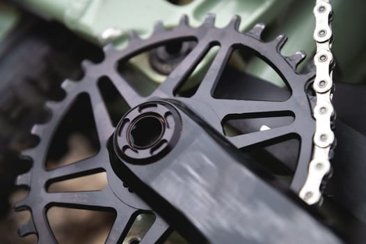 mountain bike, sprocket, chain and pedal in black. Part of a mountain bike brake disc, close-up.