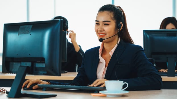 Business people wearing headset working in office to support remote customer or colleague. Call center, telemarketing, customer support agent provide service on telephone video conference call. Jivy