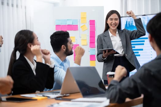 Young asian businesswoman presenting data analysis dashboard on TV screen in modern meeting. Business presentation with group of business people in conference room. Concord