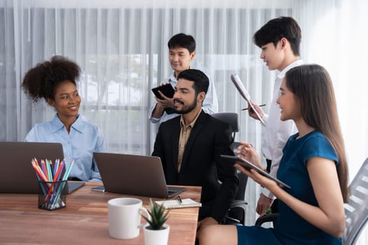 Happy diverse business people work together, discussing in corporate office. Professional and diversity teamwork discuss business plan on desk with laptop. Modern multicultural office worker. Concord