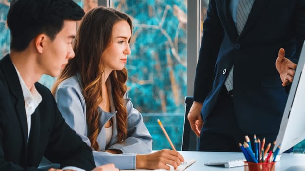 Smart businessman and businesswoman talking discussion in group meeting at office table in a modern office interior. Business collaboration strategic planning and brainstorming of coworkers. Jivy