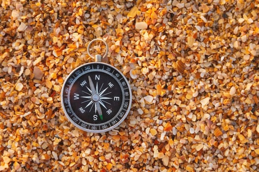 compass on sea sand and place for text. close up of navigation device on sandy beach without people, top view.