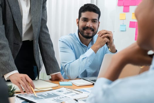 Multiracial analyst team use BI dashboard data to analyze financial report on meeting table. Group of diverse business people utilize data analysis by FIntech for business marketing decision. Concord