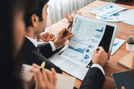 Diverse group of business analyst team analyzing financial data report paper on office table. Chart and graph dashboard by business intelligence analysis for strategic marketing planning Meticulous