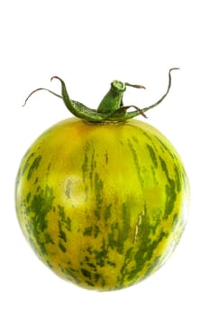 Whole fresh green zebra tomato close up and tomatoes in the background