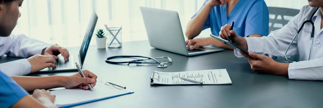 Doctor and nurse in medical meeting discussing strategic medical treatment plan together with report and laptop. Medical school workshop training concept in panoramic banner. Neoteric