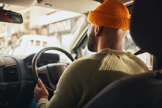 Driving, travel and a man in a car on the street in the city for traveling, driver and a commute. Back, seat and a person in transportation or a vehicle for transport on the road for a journey.