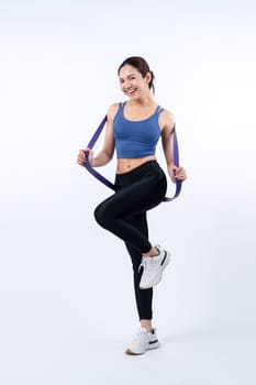 Vigorous energetic woman in sportswear portrait stretching resistance sport band. Young athletic asian woman strength and endurance training session workout routine concept on isolated background.