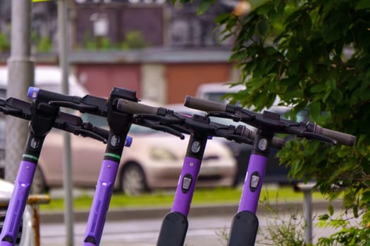 Electric scooters for the public share standing outside in the city. Selective focus