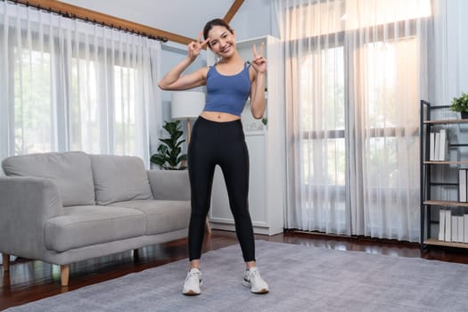 Full body asian woman in sportswear portrait, smiling and posing cheerful gesture. Home workout training with attractive girl engage in her pursuit of healthy lifestyle. Vigorous