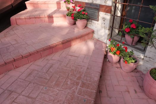 The elegant pink stairs, adorned with vibrant flower pots, add unique charm to the area