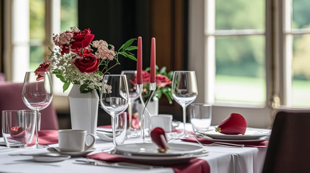 Festive table setting with candles and arrangement of beautiful red flowers. Holiday concept. High quality photo