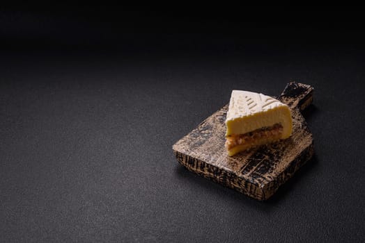 Piece of cheesecake with nuts and berries with winter pattern on dark concrete background