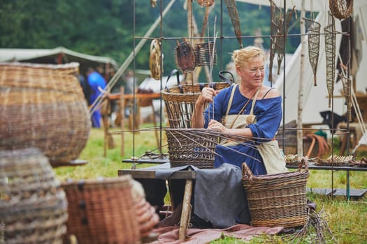 Hojbjerg, Denmark, July 27, 2024: woman weaving at a viking festival.