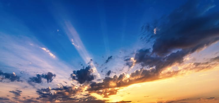 beautiful orange sunset on a blue sky with clouds. Panorama of the sky with sunlight at sunrise