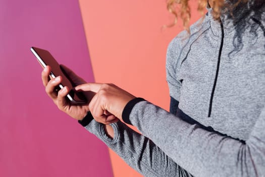 close up of the hands of an anonymous female athlete using cellphone, concept of technology of communication and modern lifestyle