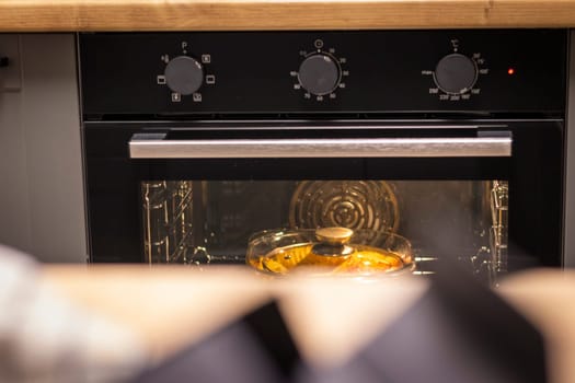 Vegetables baking in the transparent dish in the oven.