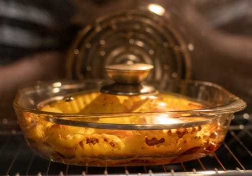 Vegetables baking in the transparent dish in the oven.