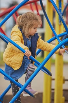 Charming child playing on a playground in Ringkobing Denmark.