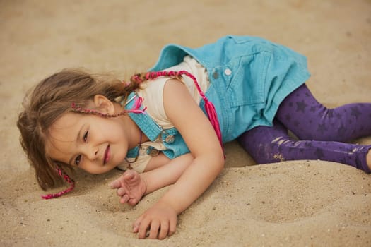 Cute child playing in a sandbox in summer Denmark.
