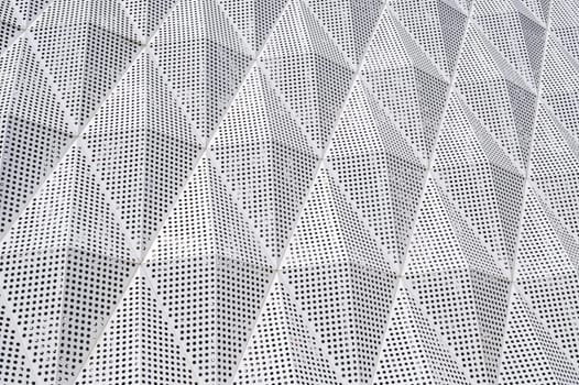 facade of a modern building is covered with geometric metal panels