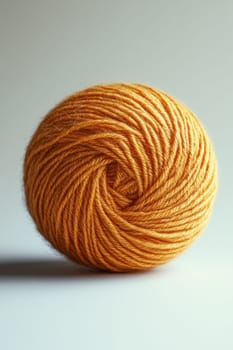 an orange ball of wool yarn highlighted on a white background.