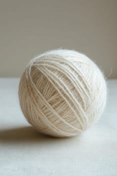 a white ball of wool yarn standing out against a white background.
