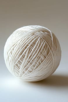 a white ball of wool yarn standing out against a white background.