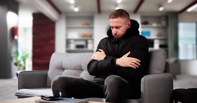 Young Man With Warm Clothing Feeling The Cold Inside House