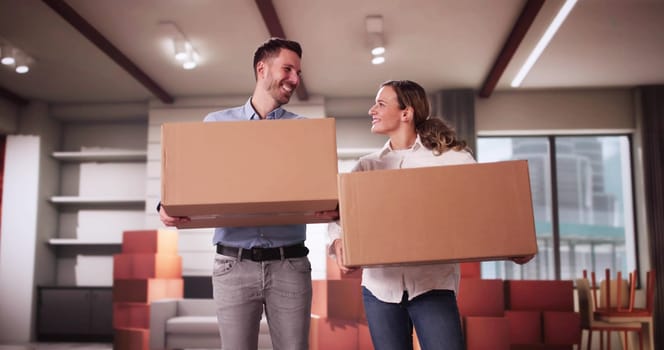 Happy Young Couple Moving Boxes In New Home