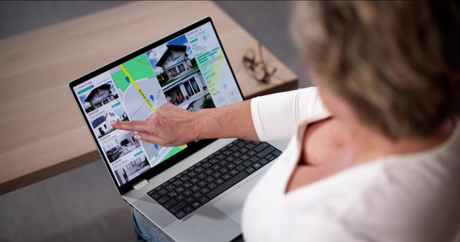 Woman Using Laptop To Search Online Real Estate Property Listings