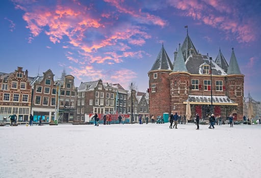 View on historical De Waag in Amsterdam in winter at sunset in the Netherlands