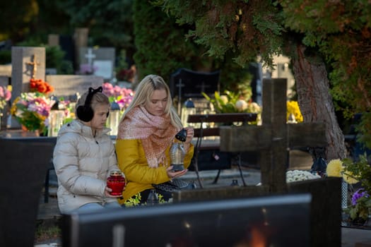 In a peaceful cemetery, two individuals share a touching and heartfelt moment, surrounded by vibrant flowers