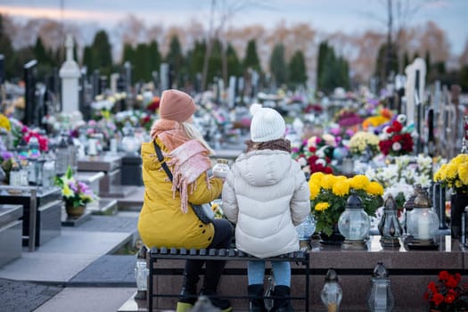 A peaceful and tranquil moment shared by two individuals in a vibrant and colorful cemetery filled with flowers