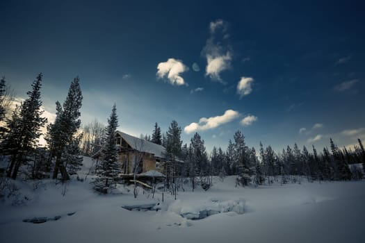 beautiful winter landscape with a village wooden hut surrounded by snow-covered trees. severe very cold winter, arctic,