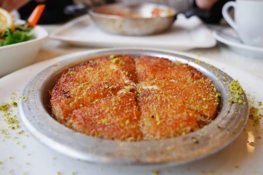 kunafa with a wipe cream on a plate