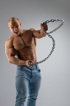 Shirtless muscular bodybuilder holding thick metal chain shot