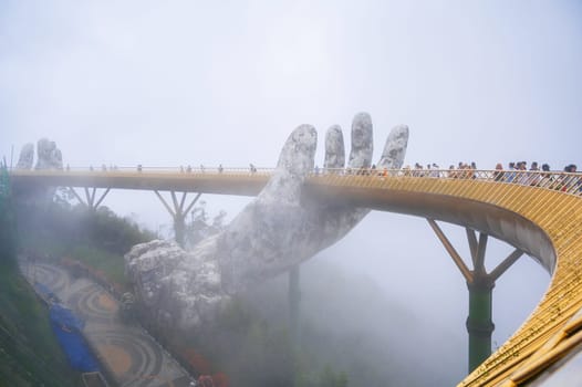 Golden Bridge or Hands of God in Ba Na Hills Park in Da Nang on the mountain in the fog. Da Nang, Vietnam - September 13, 2024