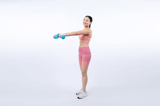 Vigorous energetic woman doing dumbbell weight lifting exercise on isolated background. Young athletic asian woman strength and endurance training session as body workout routine.