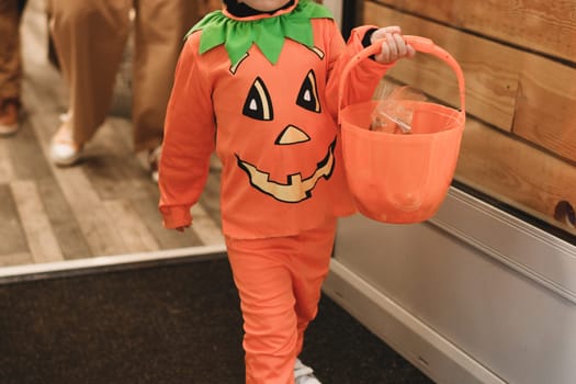 Children collecting candy on pumpking baskets at Halloween Trick or Treat event