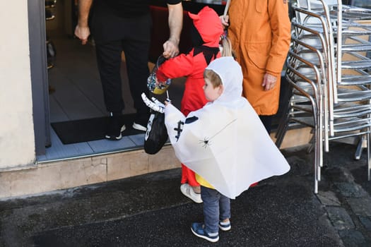 Children dressed up in the city on Halloween asking for candy