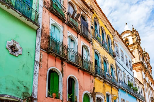 Facades of colorful houses and church in baroque and colonial style damaged by time in the Pelourinho neighborhood in the city of Salvador