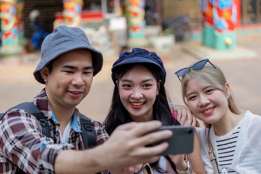 Three friends enjoying their travel adventure capturing fun moments together at a cultural site.