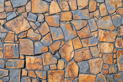 The texture of the walls is made of brown-gray stone, the background of the floor. Wide panoramic stone pattern. The surface of natural masonry.