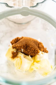 Butter and brown sugar sit together in a mixing bowl, ready to be creamed for Spiced Gingerbread Cookie Dough Perfect for Baking. The sugar is sprinkled over the softened butter, preparing for the next mixing step.