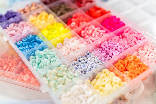 Assorted clay bead boxes neatly arranged on a white table, awaiting a creative kids' craft project.