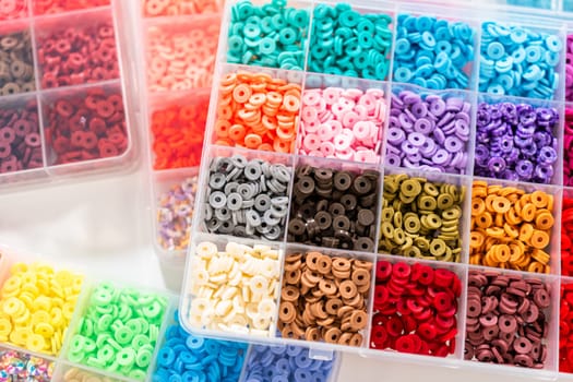 Assorted clay bead boxes neatly arranged on a white table, awaiting a creative kids' craft project.
