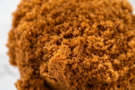 Extreme close-up of brown sugar, showcasing its coarse and moist texture, perfect for adding rich sweetness to Classic Gingerbread Cookie Dough. This ingredient is key for the dough deep flavor.