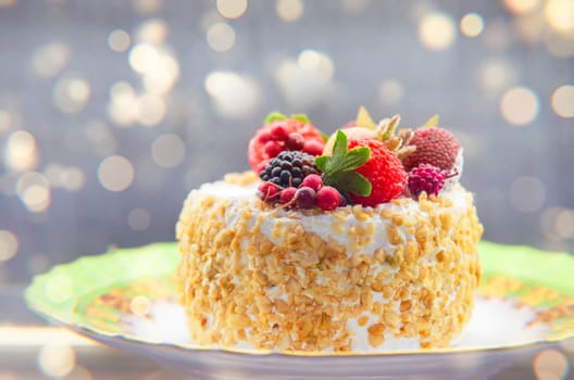 Cake covered with berries against a golden bokeh background.