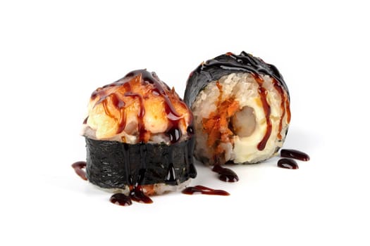 Sushi roll on a white background with Philadelphia cheese, tuna in sesame crumbs, sprinkled with soy sauce.